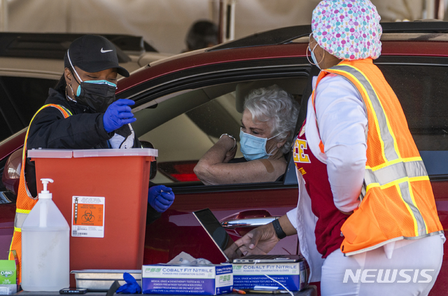 [잉글우드=AP/뉴시스]지난달 26일(현지시간) 캘리포니아 잉글우드에서 한 여성이 승용차 안에서 신종 코로나바이러스 감염증(코로나19) 백신 접종을 받고 있다. 2021.02.25.