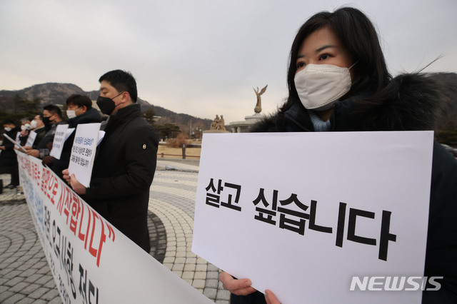 [서울=뉴시스] 박미소 기자 = 중소상인시민단체 회원들이 28일 오전 서울 종로구 청와대 분수대 앞에서 열린 '집합제한·손실보상 관련 요구사항 전달 기자회견'에서 손피켓을 들고 있다. 2021.01.28. misocamera@newsis.com