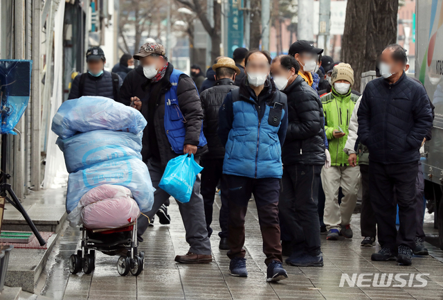 [서울=뉴시스]김병문 기자 = 노숙인들이 28일 오전 서울 용산구 서울역 인근 한 무료급식소 앞에서 배식을 기다리고 있다. 신종 코로나바이러스 감염증(코로나19) 확진자가 발생한 서울역 희망지원센터는 지난 26일부터 운영이 중단되고 있다. 2021.01.28.  dadazon@newsis.com