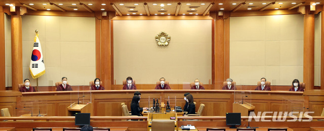 [서울=뉴시스]김선웅 기자 = 유남석 헌법재판소장과 헌법재판관들이 28일 오후 서울 종로구 헌법재판소 대심판정에서 열린 고위공직자범죄수사처에 대해 청구된 헌법소원 심판 사건 선고를 위해 입장해 자리에 앉아있다. (공동취재사진) 2021.01.28. photo@newsis.com