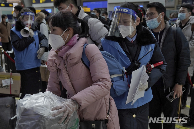 [베이징=AP/뉴시스] 1월28일(현지시간) 중국 베이징 남역에서 신종 코로나바이러스 감염증(코로나19) 확산을 막기 위해 마스크와 페이스 실드(얼굴 가리개)를 착용한 승객·직원들의 모습. 2021.02.01.  