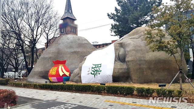 [대구=뉴시스]이지연 기자 = 대구 달서구 진천동 선사시대로 원시인 조형물에 복주머니가 설치됐다. (사진=달서구청 제공) 2021.02.02. photo@newsis.com