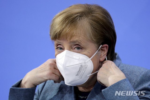 [베를린=AP/뉴시스] 1일(현지시간) 앙겔라 메르켈 독일 총리가 베를린에서 열린 화상 기자회견 직전 마스크를 벗고 있다. 2021.02.10.
