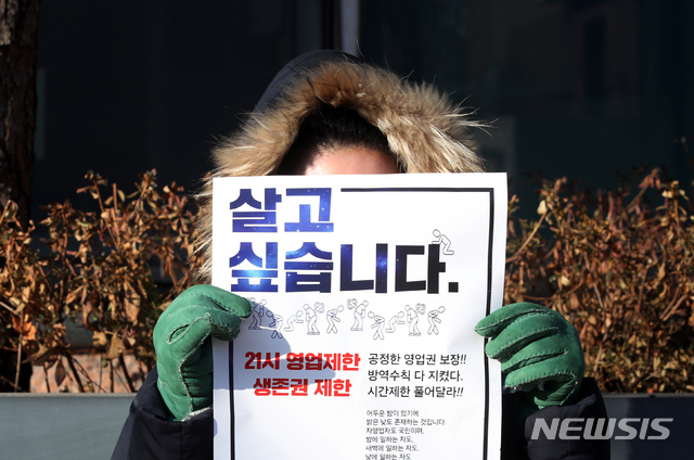 [서울=뉴시스]김병문 기자 = '사회적거리두기 단계 개편을 위한 공개토론회'가 열린 지난 2일 오전 서울 중구 LW컨벤션에 마련된 토론회장 앞에서 자영업자들이 방역지침 끝장토론, 영업시간 연장 등을 촉구하는 1인 시위하고 있다. 2021.02.02. dadazon@newsis.com