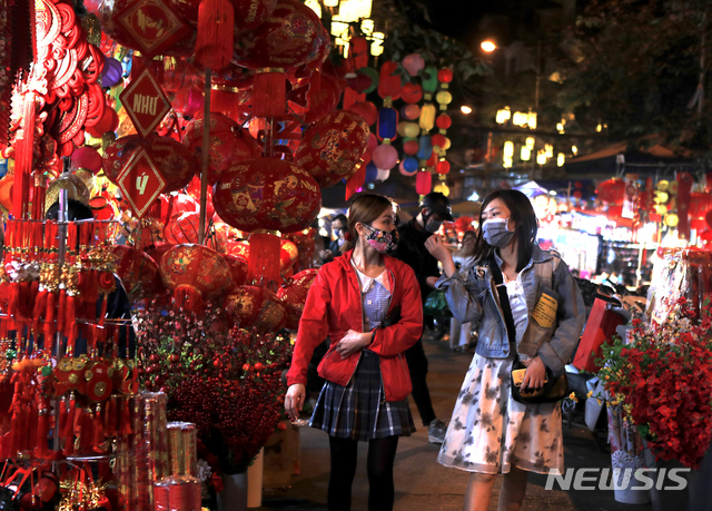 [하노이=AP/뉴시스]7일(현지시간) 베트남 하노이에서 '텟'으로 알려진 12일의 설을 앞두고 마스크를 쓴 여성들이 설맞이 장식을 사기 위해 장을 보고 있다. 2021.02.08.