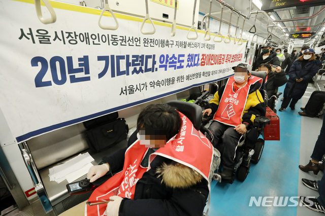 [서울=뉴시스]배훈식 기자 = 서울장애인차별철폐연대 회원들이 지난 2월 10일 오후 서울 중구 지하철 4호선 충무로역 서울역 방면 열차에서 장애인 이동권 보장을 촉구하며 승하차 시위를 하고 있다. 2021.02.10. dahora83@newsis.com