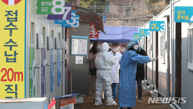 [서울=뉴시스]김명원 기자 = 13일 서울 용산구 순천향대학교 서울병원에서 신종 코로나바이러스 감염증(코로나19) 확진자가 37명이 나온 가운데 임시선별진료소에는 검사를 받으려는 사람들과 의료진이 분주히 움직이고 있다. 순천향대병원 관계자에 따르면 환자 29명, 간호사 7명, 보호자 1명 등 37명의 확진자가 발생했다. 2021.02.13. kmx1105@newsis.com