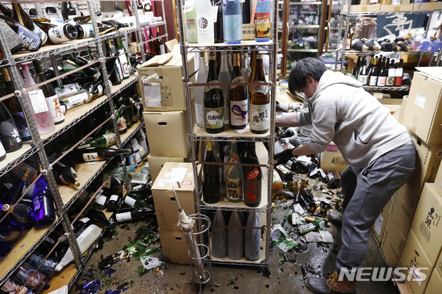 [후쿠시마=AP/뉴시스]14일 일본 후쿠시마에서 한 주류 상점 직원이 전날 밤 지진으로 피해 본 가게를 정리하고 있다. 13일 오후 11시 8분경 후쿠시마현 앞바다에서 규모 7.3의 강진이 발생했지만 쓰나미 위험은 없다고 기상청은 밝혔다. 2021.02.14.