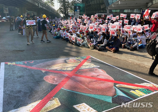 [양곤/AP=뉴시스]14일 미얀마 양곤에서 반군부 시위대가 시위를 벌이고 있다. 쿠데타를 일으킨 미얀마군 최고사령관의 사진에 붉은색으로 X표시를 한 사진이 바닥에 놓여있다. 2021.02.15. 