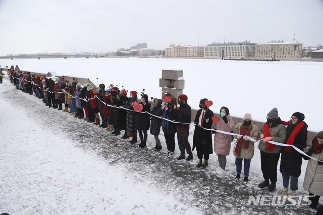 [상트페테르부르크=AP/뉴시스] 2021년 2월14일 러시아 상트페테르부르크에서 귀국 직후 수감된 반체제 지도자 알렉세이 나발니와 그의 아내 율리아를 지지하는 여성들이 인간 띠를 형성하고 나발니의 석방을 촉구하는 시위를 벌이고 있다. 2021.02.15.