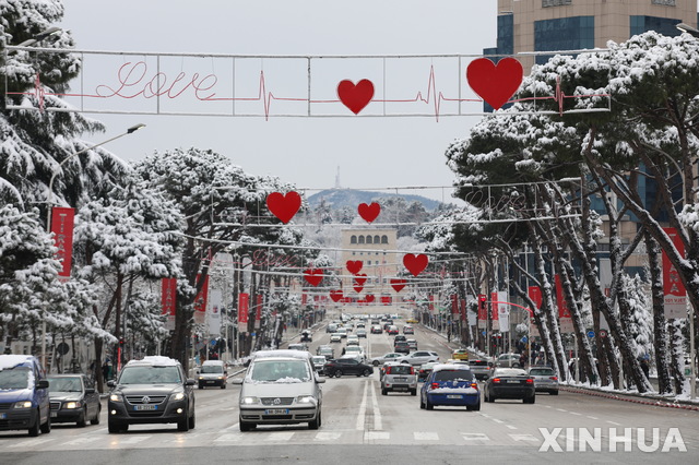 [티나라=신화/뉴시스]14일(현지시간) 알바니아 수도 티라나 가로수에 눈이 쌓인 가운데 밸런타인데이 장식이 설치돼 있다. 2021.02.15.