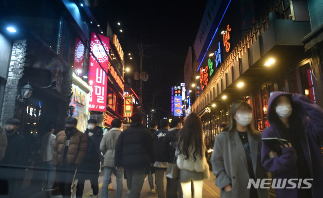 [대구=뉴시스] 이무열 기자 = 비수도권 사회적 거리 두기가 1.5단계로 완화된 지난 2월 15일 저녁 대구 중구 동성로의 불 켜진 상점 간판 사이로 시민들이 지나가고 있다. 2021.02.15. lmy@newsis.com