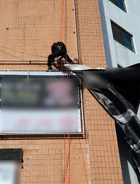 [부산=뉴시스] 강풍주의보가 발효 중인 17일 부산 북구의 한 건물 외벽에 설치된 대형 현수막이 강풍에 찢어지자 소방대원이 제거하고 있다. (사진=부산소방재난본부 제공). 2021.02.17. photo@newsis.com&nbsp; *재판매 및 DB 금지