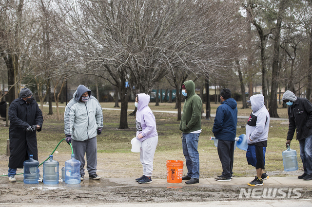 [휴스턴=AP/뉴시스] 18일(현지시간) 미국 텍사스주 휴스턴에 있는 공원에서 물을 받아가려는 사람들이 줄을 선 모습. 텍사스 주민들은 이례적인 한파로 인해 대규모 단수 사태를 겪고 있다. 2021.02.19. 