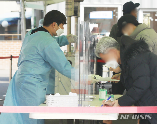 [서울=뉴시스]조수정 기자 = 코로나19 신규확진자가 0시 기준 416명으로 이틀째 400명대를 기록한 21일 서울역 중구 임시선별검사소에서 시민들이 검사를 받기 위해 서류를 작성하고 있다. 2021.02.21. chocrystal@newsis.com