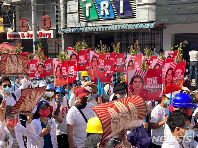 [만달레이=AP/뉴시스]22일 미얀마 만달레이에서 군부 쿠데타 반대 집회가 열려 아웅산 수지 국가고문 얼굴이 있는 팻말을 든 시위대가 행진하고 있다.  미얀마 시민불복종운동은 미얀마 전역에서의 총파업을 촉구하는 시위를 벌이면서 군부는 '무력진압'을 경고하고 있어 대규모 충돌이 우려되고 있다. 2021.02.22.