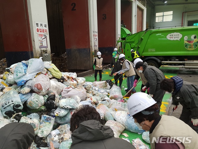 [수원=뉴시스]지난 22일 수원 파장·율천·정자1동 주민들과 주민지원협의체 주민들이 자원회수시설로 반입된 종량제 봉투를 뜯어 기준에 못 미치는 쓰레기가 있는 지 확인하고 있다.(수원시 제공)