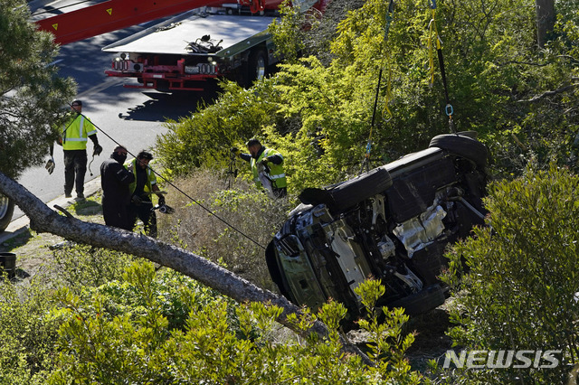 [로스앤젤레스=AP/뉴시스]미 프로골프선수 타이거 우즈가 타고 있던 차량이 23일(현지시간) 미 캘리포니아주 로스앤젤레스 카운티 란초 팔로스 베르데스 인근에서 전복돼 작업자들이 이를 옮기고 있다. 우즈는 이 사고로 다리를 다쳐 병원으로 이송돼 수술을 받고 있다고 그의 매니저 마크 스타인버그가 밝혔다. 2021.02.24.