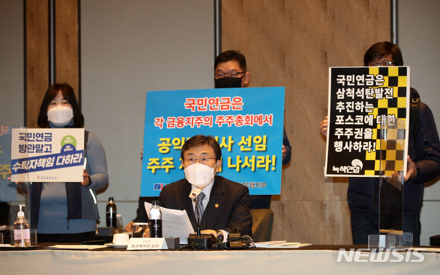 [서울=뉴시스]고범준 기자 = 권덕철 보건복지부 장관이 24일 오후 서울 종로구 포시즌스 호텔 그랜드볼룸에서 열린 제2차 국민연금기금운용위원회에 참석해 발언을 하고 있다. 이번 회의에서 전국금융산업노동조합 KB국민은행지부, 민주노총 전국공공운수노동조합 국민연금지부, 녹색연합 등 시민단체가 국민연금 주주권 행사를 촉구하며 피켓팅을 하고 있다. 2021.02.24. bjko@newsis.com