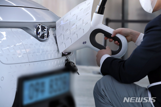 [서울=뉴시스]이윤청 기자 = 24일 서울 강동구 현대 EV스테이션 강동에서 한 직원이 코나 전기차량을 충전하고 있다. 2021.02.24. radiohead@newsis.com