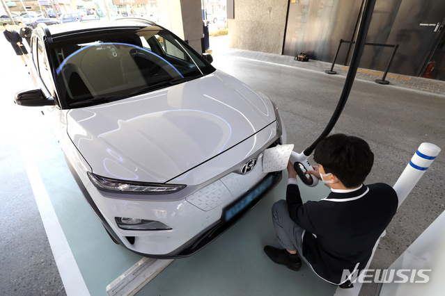 [서울=뉴시스]이윤청 기자 = 국토교통부가 현대자동차에서 제작 판매한 코나 전기차 등 3개 차종 2만6699대에서 배터리 결함이 발견돼 자발적 시정조치(리콜)한다고 밝힌 24일 서울 강동구 현대 EV스테이션 강동에서 한 직원이 코나 전기차량을 충전하고 있다. 2021.02.24. radiohead@newsis.com