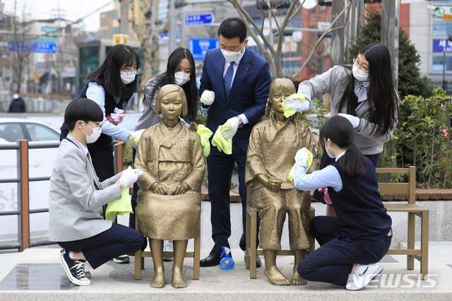 [서울=뉴시스]박민석 기자 = 이승로 성북구청장과 계성고등학교 학생들이 25일 오전 서울 성북구 한성대입구역 앞 분수마루에서 평화의소녀상을 닦고 있다. 2021.02.25. mspark@newsis.com