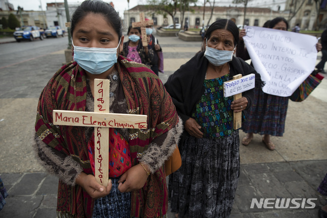 [과테말라시티=AP/뉴시스]지난 2021년 2월25일(현지시각) 과테말라 수도 과테말라시티 국립궁전 앞에서 원주민 여성들이 내전 희생자들의 이름이 쓰인 십자가들 들고 존엄의 날 기념식에 참석하고 있다. 과테말라 법원이 30일 40여년 전 원주민 여성을 강간한 군과 경찰 3명에 40년형을 선고했다. 2025.5.31. 