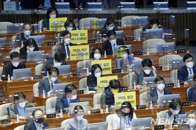 [서울=뉴시스]최동준 기자 = 정의당 의원들이 26일 서울 여의도 국회 본회의에서 가덕도 관련 법안을 비판하는 피켓을 의석에 붙여 놓고 있다. 2021.02.26. photocdj@newsis.com