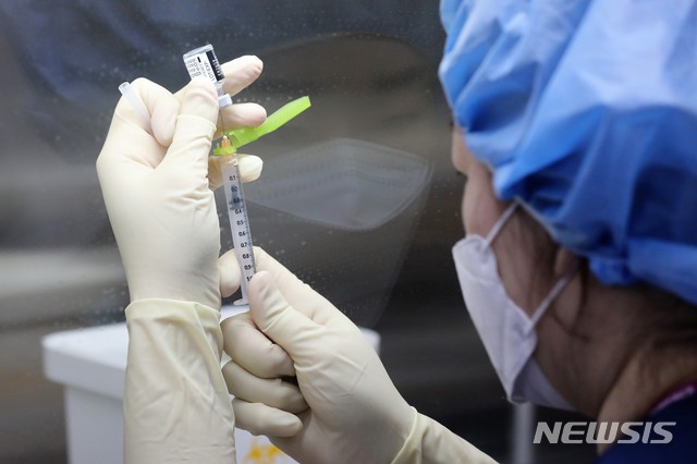 [서울=뉴시스]사진공동취재단 = 코로나19 환자 치료 의료진을 대상으로 한 화이자 백신 접종이 시작된 27일 오전 서울시 중구 국립중앙읭료원 중앙예방접종센터 내 무균 작업대(클린벤치)에서 의료진이 화이자 백신을 주사기에 소분 조제하고 있다. 2021.02.27. photo@newsis.com