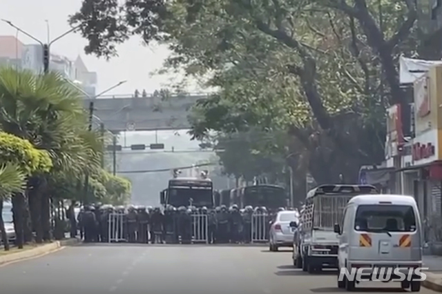 [양곤=AP/뉴시스]27일 동영상을 갈무리한 이 사진에서 진압 장비를 착용한 미얀마 군경이 군부 쿠데타에 항의하는 시위대를 해산하기 위해 줄지어 서 있다. 2021.02.27. 