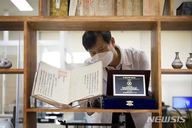 [서울=뉴시스]동의보감·자산어보가 국가중요과학기술자료로 등록됐다. 등록패를 정리하는 국립중앙도서관 학예연구사. (사진 = 국립중앙도서관 제공) 2021.03.01.photo@newsis.com