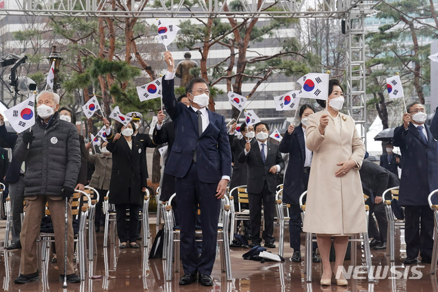 [서울=뉴시스]추상철 기자 = 문재인 대통령와 김정숙 여사가 1일 오전 서울 종로구 탑골공원에서 열린 제102주년 31절 기념식에 참석해 태극기를 흔들고 있다. 2021.03.01. scchoo@newsis.com
