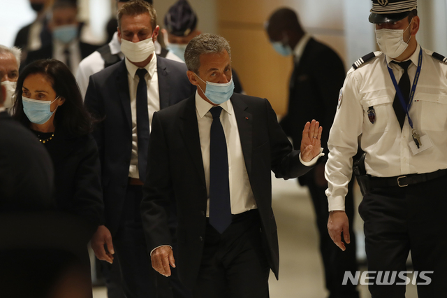 [파리=AP/뉴시스] 니콜라 사르코지 전 프랑스 대통령이 1일 부패 독직 혐의 선고가 내려지는 법정으로 들어가면서 손을 흔들고 있다