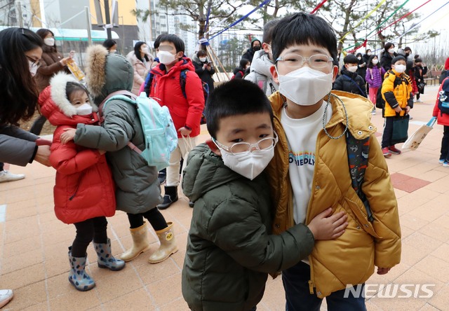 [서울=뉴시스]사진공동취재단 = 2021학년도 초·중·고교 신학기 첫 등교가 시작된 2일 오전 서울 강동구 강빛초등학교에서 재학생 동생들이 형, 누나를 안아주고 있다. 2021.03.02. photo@newsis.com