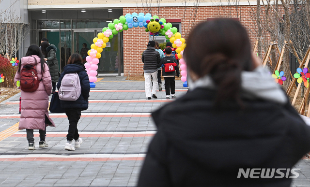 [서울=뉴시스]사진공동취재단 = 전국적으로 개학이 시작된 2일 오전 서울 강동구 강빛초중이음학교에서 학부모가 등교하는 초등학생을 바라보고 있다. 오늘부터 유치원생과 초등학교 1~2학년, 고등학교 3학년은 매일 등교한다. 나머지 학년은 격주, 격일 등 학교별로 조정해 수도권 밀집도 3분의 1, 비수도권 3분의 2 까지 등교한다. 2021.03.02. photo@newsis.com