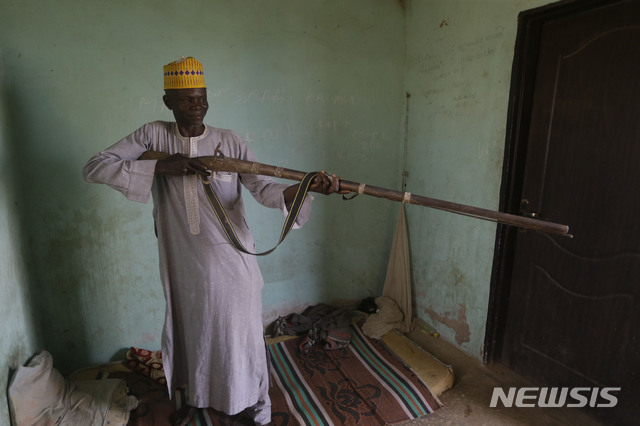 [장게베=AP/뉴시스]총을 든 경비원 라와니 아달리가 1일(현지시간) 나이지리아 북부 잠파라 주 장게베에서 국립여자중학교 학생 317명의 납치 상황에 관해 얘기하고 있다. 아달리는 당시 학교에 침입해 사방을 봉쇄한 무장 괴한들이 "신은 위대하다"라고 소리치며 심하게 발포해 경찰과 자경단이 진입할 수 없었다고 상황을 설명했다. 지난달 26일 무장 괴한들에 납치된 아이들의 소재가 파악되지 않은 가운데 가족은 애타게 소식을 기다리고 있다. 2021.03.02. 