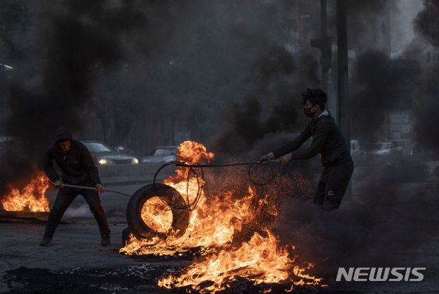 [베이루트=AP/뉴시스]지난 3월2일(현지시간) 레바논 베이루트에서 반정부 시위대가 베이루트 국제공항으로 통하는 고속도로를 막기 위해 타이어에 불을 지르고 있다. 2021.06.18