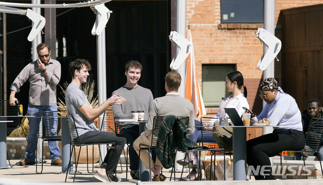 [댈러스=AP/뉴시스] 3일(현지시간) 미국 텍사스주 댈러스에 있는 가게 야외 자리에서 사람들이 이야기를 나누고 있다. 코로나19에도 마스크를 착용하지 않은 모습이다. 2021.03.04. 