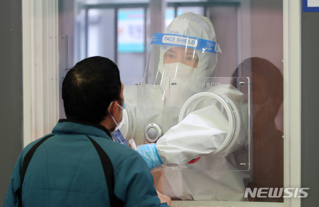 [서울=뉴시스]배훈식 기자 = 지난 4일 오전 서울 중구 서울역 광장에 마련된 코로나19 임시 선별검사소에서 의료진이 검체를 채취하고 있다. 2021.03.04. dahora83@newsis.com