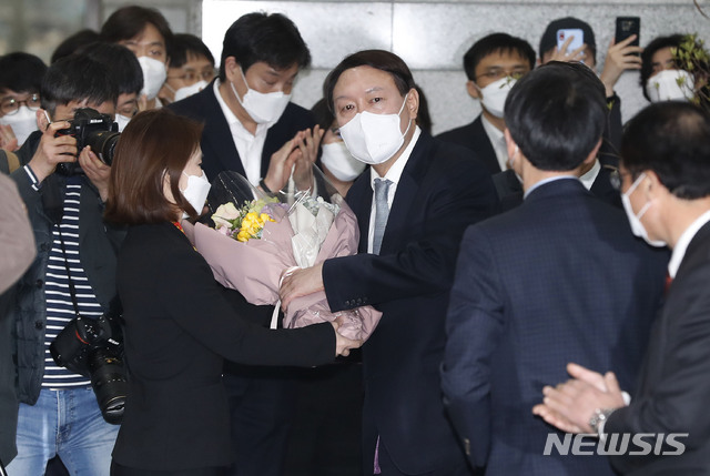 [서울=뉴시스]홍효식 기자 = 사의를 표명한 윤석열 전 검찰총장이 4일 오후 서울 서초구 대검찰청을 떠나며 직원에게 꽃다발을 받고 있다. 2021.03.04. yesphoto@newsis.com