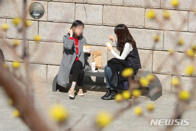 [서울=뉴시스]배훈식 기자 = 지난 5일 오후 서울 종로구 청계천을 찾은 시민들이 햇살을 맞으며 점심을 먹고 있다. 2021.03.05. dahora83@newsis.com