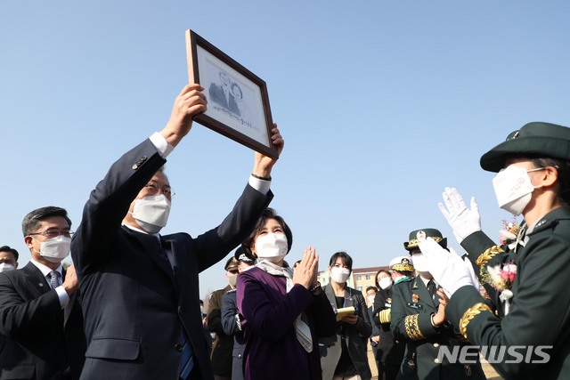 [대전=뉴시스]추상철 기자 = 문재인 대통령이 5일 대전광역시 국군간호사관학교에서 열린 제61기 졸업 및 임관식에 참석해 졸업생도로부터 받은 선물을 들어보이고 있다. 2021.03.05. scchoo@newsis.com