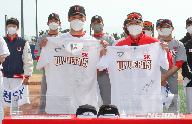 [서귀포=뉴시스]우장호 기자 = 신세계그룹 이마트에 매각된 KBO 프로야구팀 SK 와이번스 선수단이 5일 오후 제주 서귀포시 강창학야구장에서 스프링캠프 마지막 훈련을 소화한 뒤 유니폼을 반납하는 세리모니를 하고 있다. 주장 이재원(앞줄 왼쪽) 선수와 김원형 감독이 유니폼을 들고 기념촬영하고 있다. 2021.03.05. woo1223@newsis.com