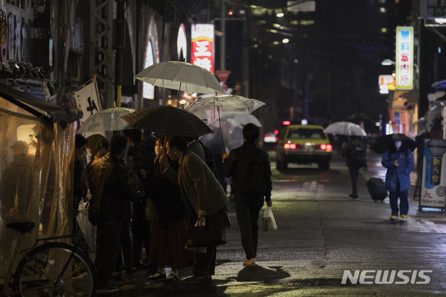 [도쿄=AP/뉴시스] 일본 직장인들이 5일 밤 수도 도쿄 시내에서 코로나19 확산 방지를 위한 긴급사태 선언 발령으로 오후 8시까지만 식당과 주점 등이 영업을 하자 이후에도 문을 연 포장마차에 몰려가 차례를 기다리고 있다. 2021.03.07