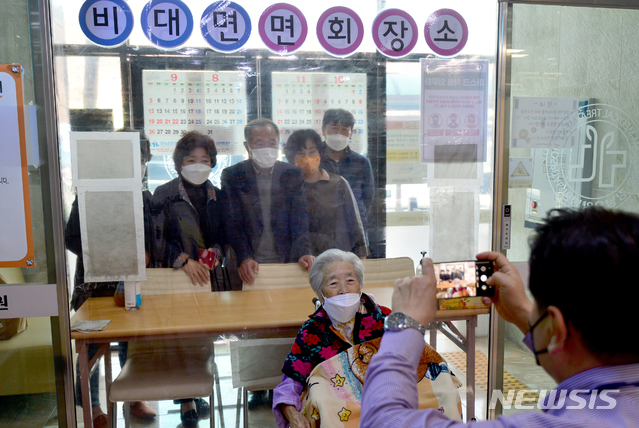 [광주=뉴시스] 김혜인 기자 = 방역수칙 조정에 따라 요양병원 면회가 허용된 9일 오전 광주 동구 소태동 강남요양병원에서 병원관계자가 면회 기념 가족 사진을 촬영하고 있다. 2021.03.09. hyein0342@newsis.com