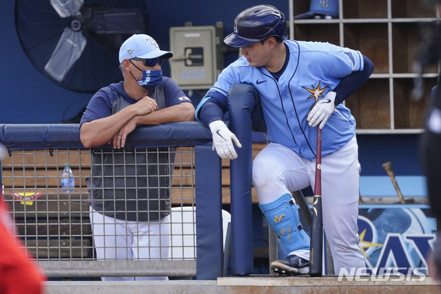 [포트샬럿=AP/뉴시스]탬파베이 레이스 최지만(오른쪽)이 9일(현지시간) 미 플로리다주 포트샬럿에서 열린 보스턴 레드삭스와의 시범 경기 중 더그아웃에서 케빈 캐시 감독과 얘기를 나누고 있다. 최지만은 6회 교체되기까지 2타수 1안타 1타점 1득점을 기록했다. 2021.03.10.