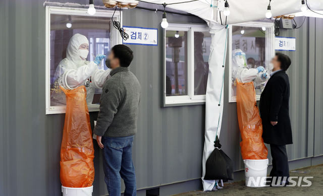 [서울=뉴시스]홍효식 기자 = 코로나19 신규 확진자가 470명으로 집계된 10일 오후 서울역 광장에 마련된 중구 임시 선별검사소에서 의료진이 시민들의 검체를 채취하고 있다. 2021.03.10. yesphoto@newsis.com