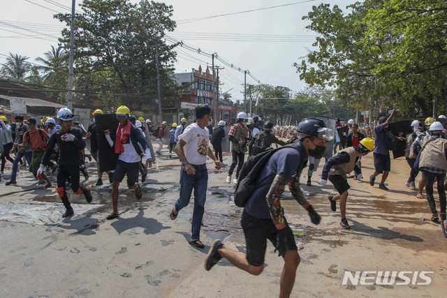 [양곤=AP/뉴시스]11일 미얀마 양곤에서 경찰이 반 군부 시위대를 향해 고무탄을 쏘고 음향 폭탄을 터트리자 시위대가 시위 일선에서 퇴각하고 있다. 국제사면위원회(앰네스티)는 미얀마 군정이 평화 시위대를 상대로 실전용 무기를 점점 많이 사용하고 있으며 조직적이고 계획적인 살상을 저지르고 있다고 비난했다. 2021.03.11.