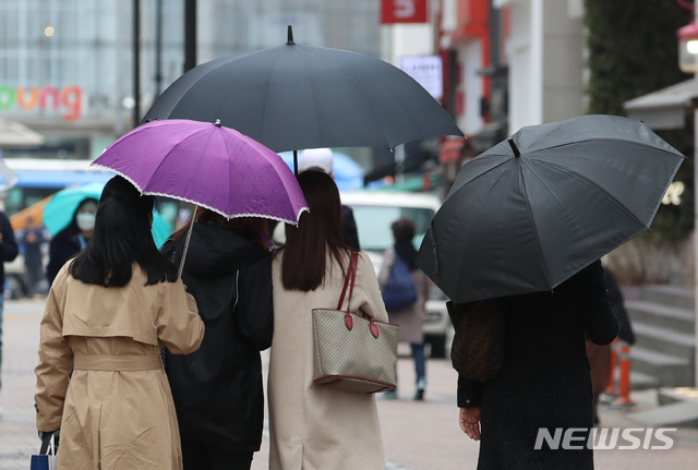 [서울=뉴시스]고승민 기자 = 전국에 봄비가 내리기 시작한 지난 12일 서울 명동 거리에서 시민이 우산을 쓰고 있다. 2021.03.12. kkssmm99@newsis.com