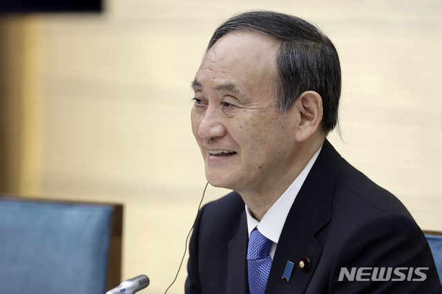 [도쿄=AP/뉴시스] 지난 12일 밤 일본 도쿄 총리 관저에서 스가 요시히데(오른쪽) 총리가 화상 형식으로 열린 미국·일본·호주·인도의 대중 안보 연합체 '쿼드(Quad)' 첫 정상회의를 가지며 웃고 있다. 2021.03.15.